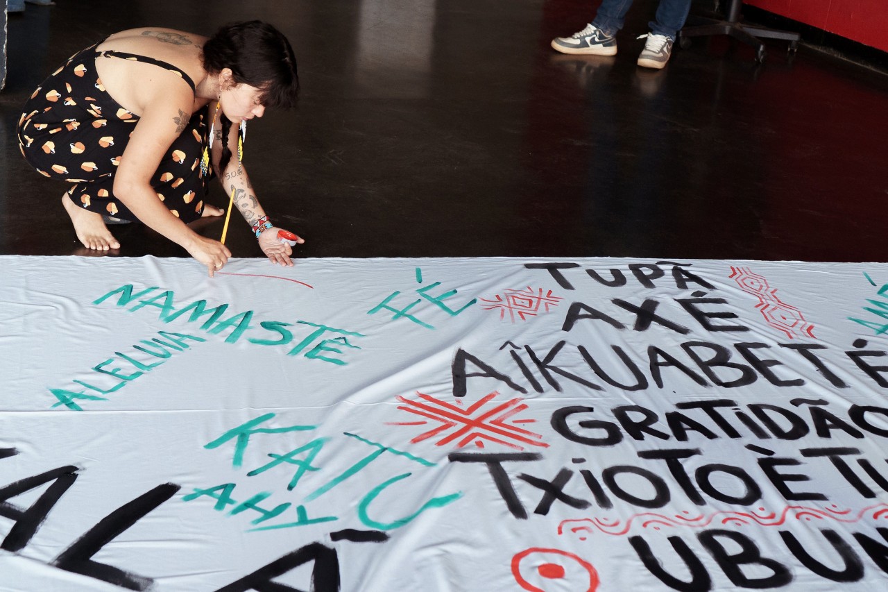 Religious interjections were painted on a large banner during the event. Image: Gabriel Della Giustina / COP30